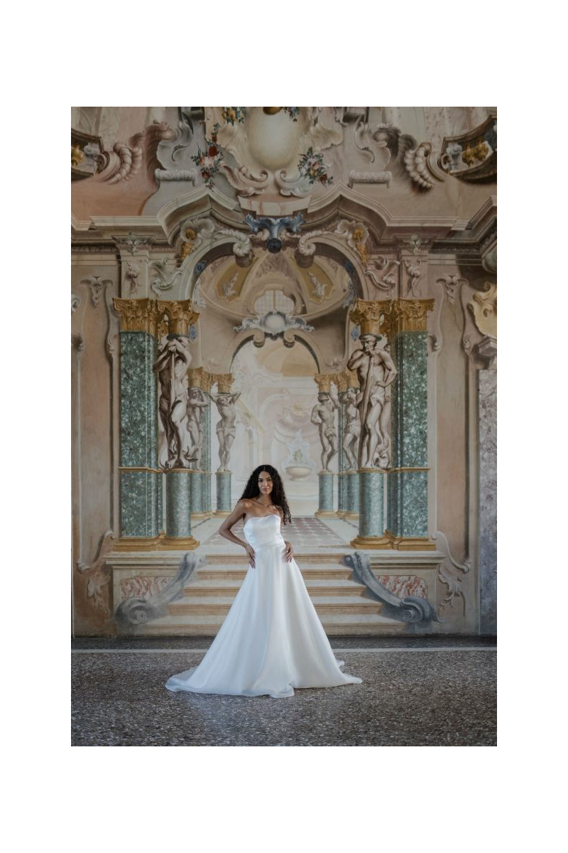 Abito da sposa GEMINI LINEA SPOSAE ATELIER in un elegante ambiente storico con dettagli artistici.
