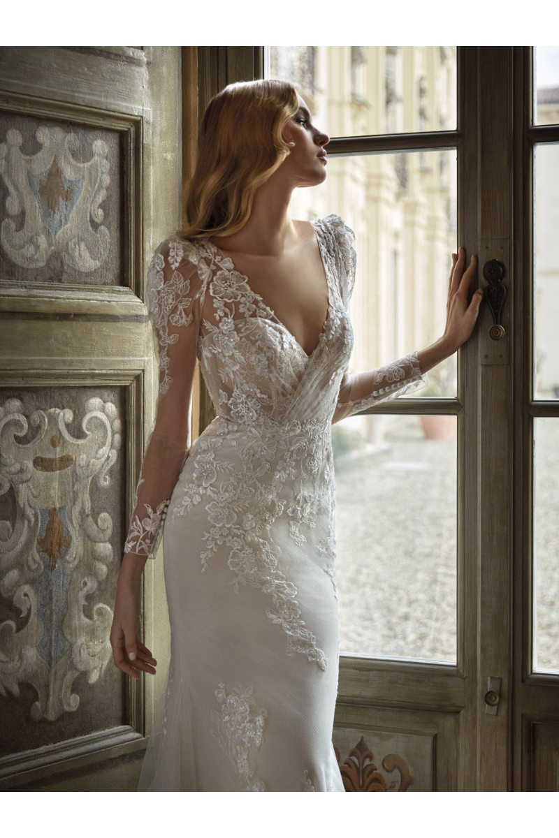 Abito da sposa NAHUEL di Nicole Milano con dettagli in pizzo, maniche lunghe e scollatura profonda.