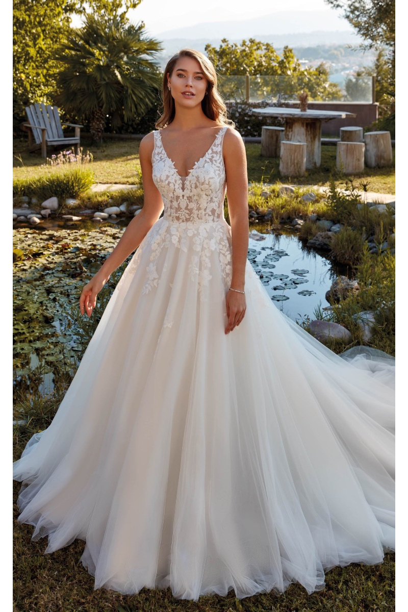 Abito da sposa Eddy K PENNY in tulle con dettagli floreali, sfondo naturale.