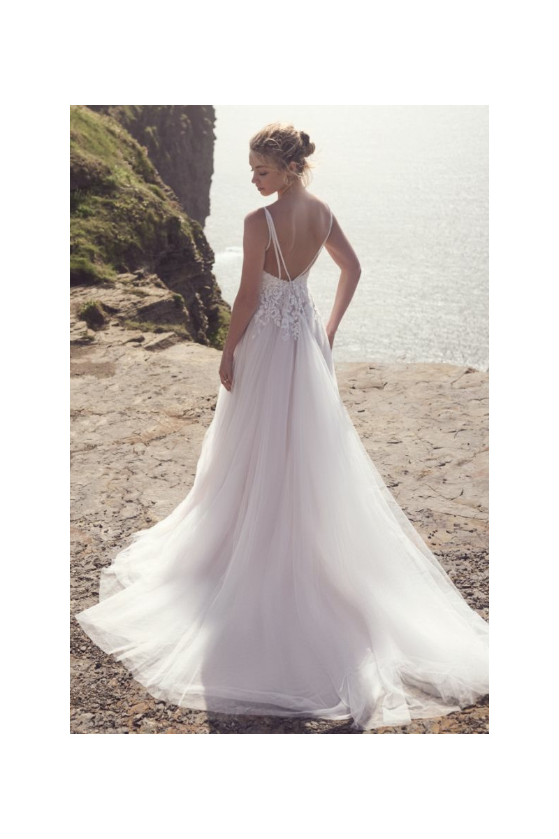 Abito da sposa Cassidy di Maggie Sottero, scollatura bassa, sfondo scogliera e mare.