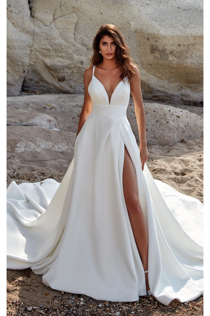 Abito da sposa Rome di Eddy K con spacco, scollatura a V, ambientato su sfondo roccioso.