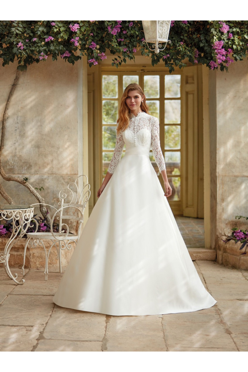 Abito da sposa ROSAMEL di Nicole Colet con corpetto in pizzo e maniche lunghe, ambientazione romantica.