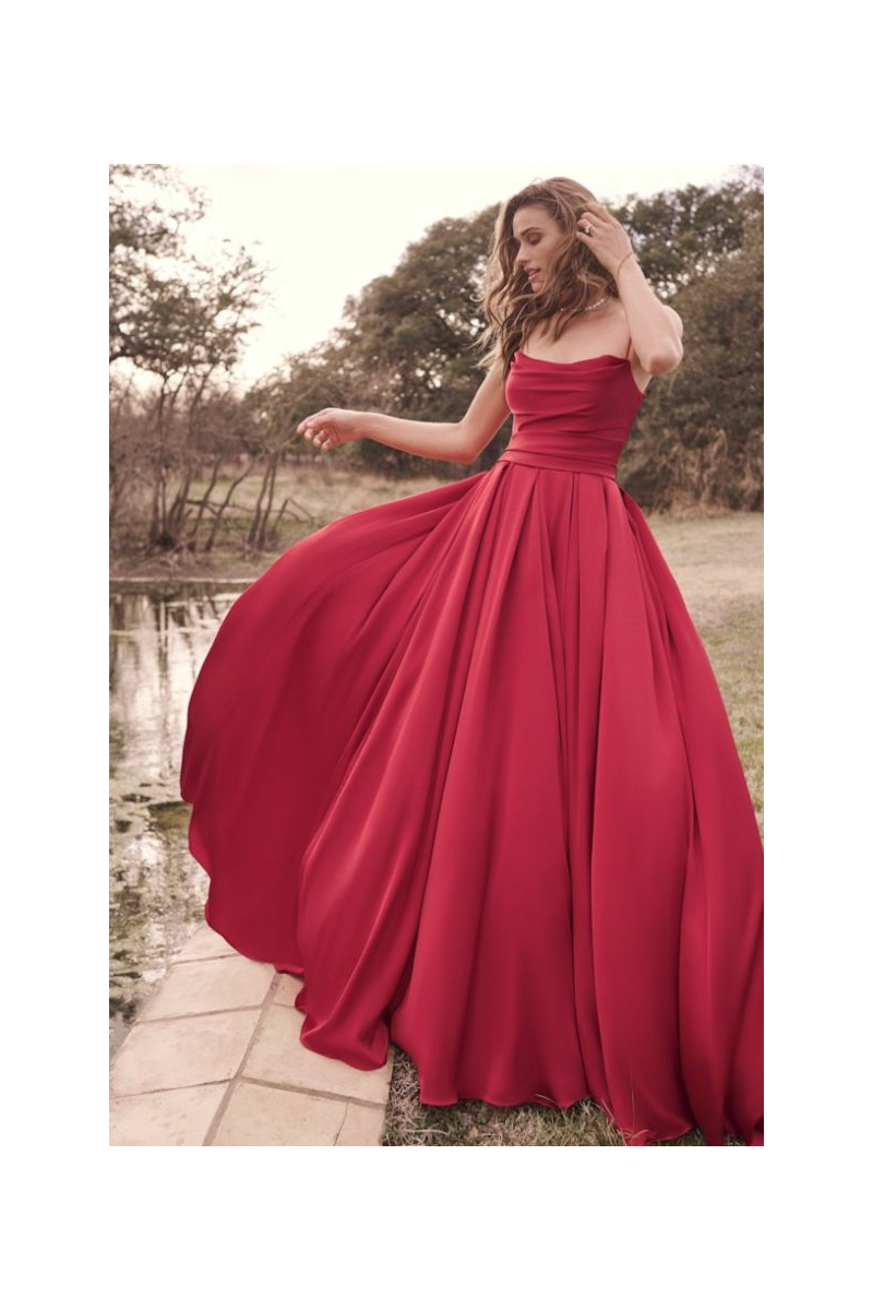 Abito da sera rosso SCARLET di Maggie Sottero, silhouette fluida, ambientato all'aperto.