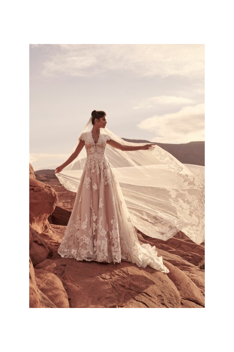 Abito da sposa KINGSLEY di Maggie Sottero con pizzo floreale, ambientato in un paesaggio desertico.