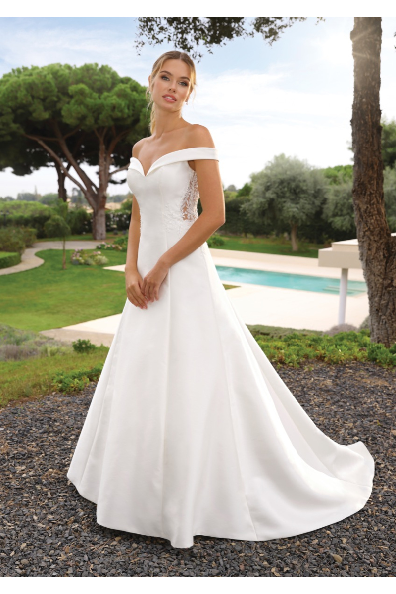 Abito da sposa TAHIRA Ladybird bianco, scollo a cuore, sfondo giardino e piscina.