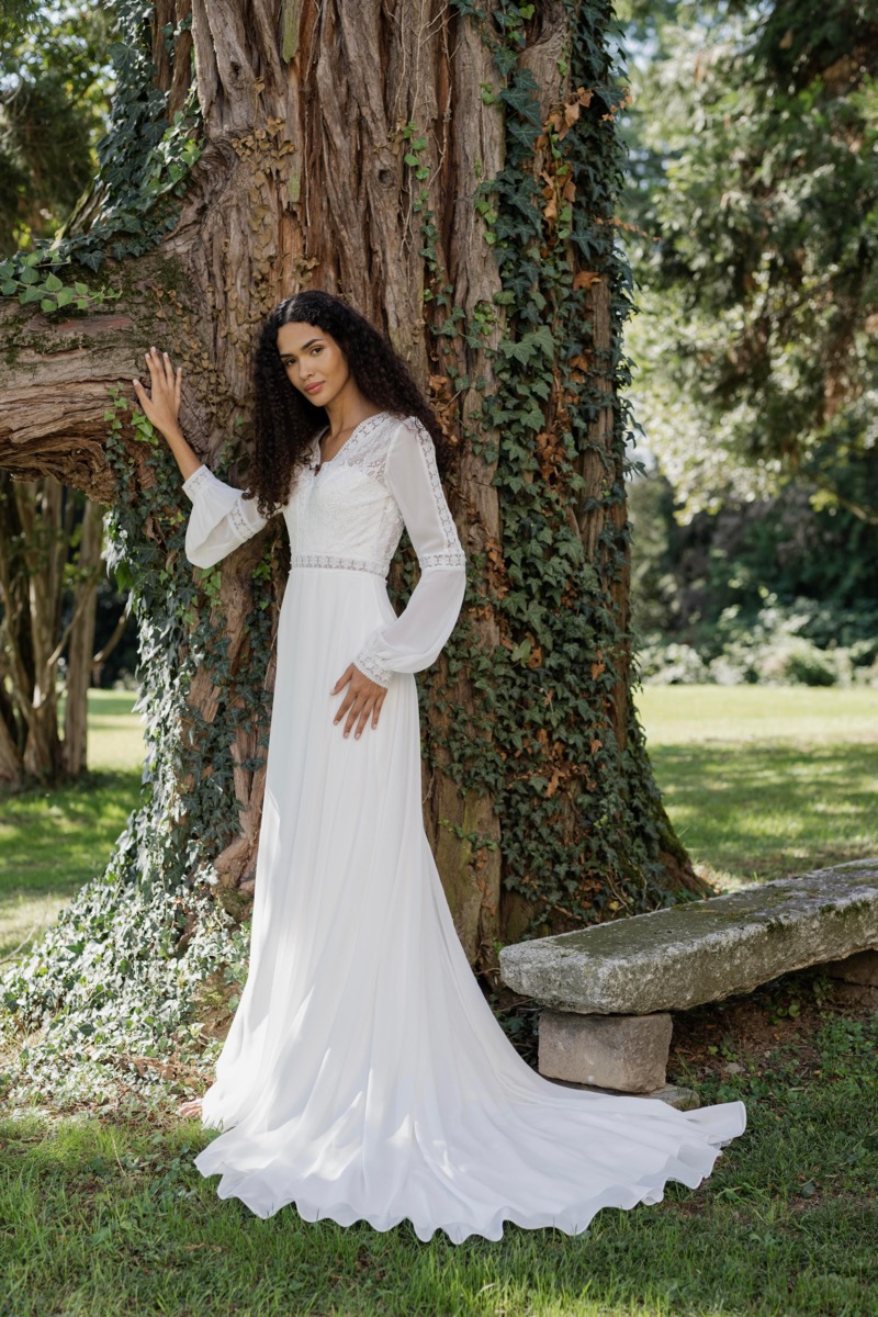 Abito da sposa Galveston Linea Sposae Atelier, donna appoggiata a un albero in giardino.