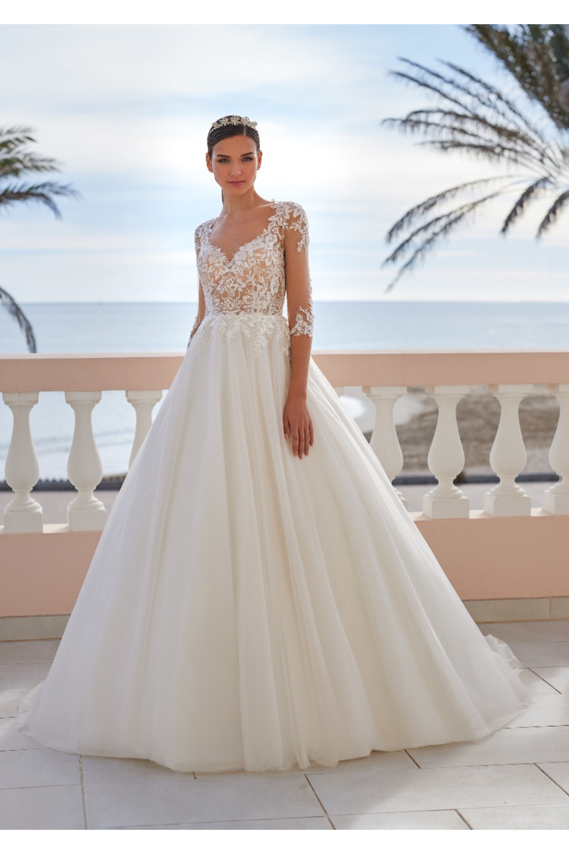 Abito da sposa Vague St. Patrick con dettagli in pizzo, sfondo mare e palme.