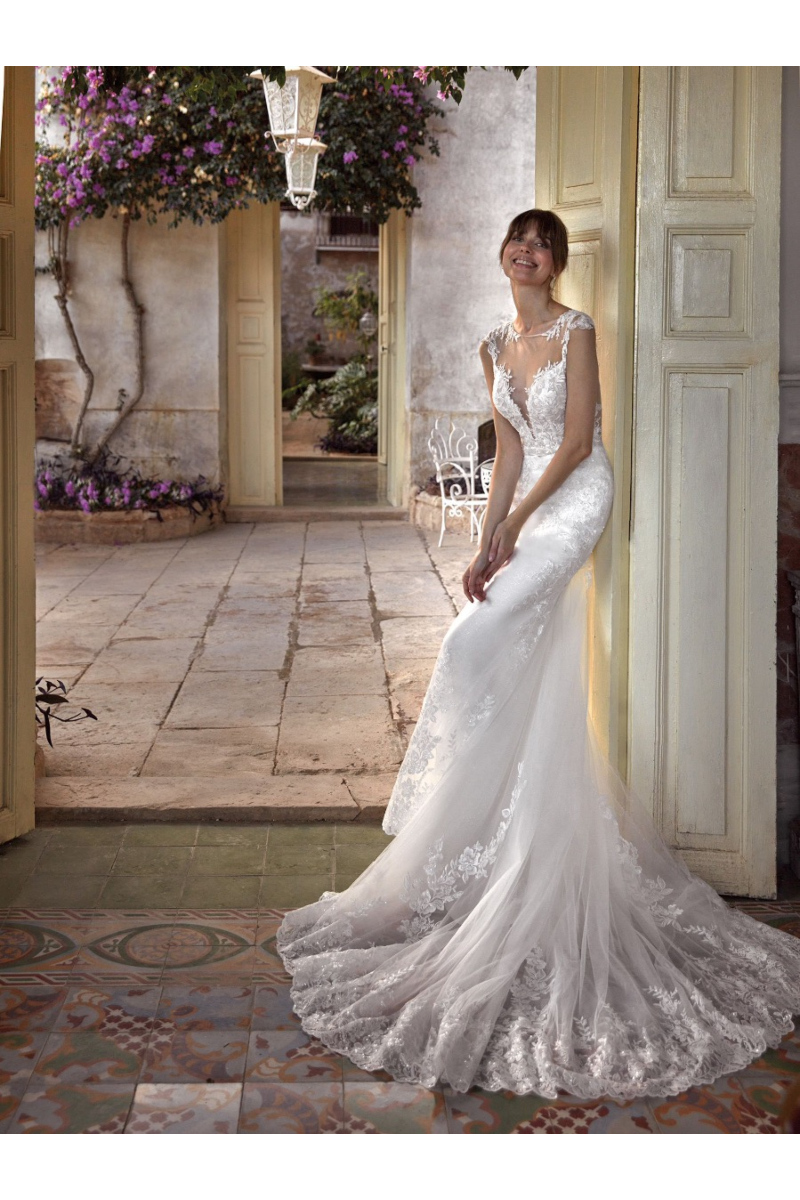 Abito da sposa VIOLETTA di Nicole Colet, elegante e ricamato, indossato da una modella in un ambiente rustico.