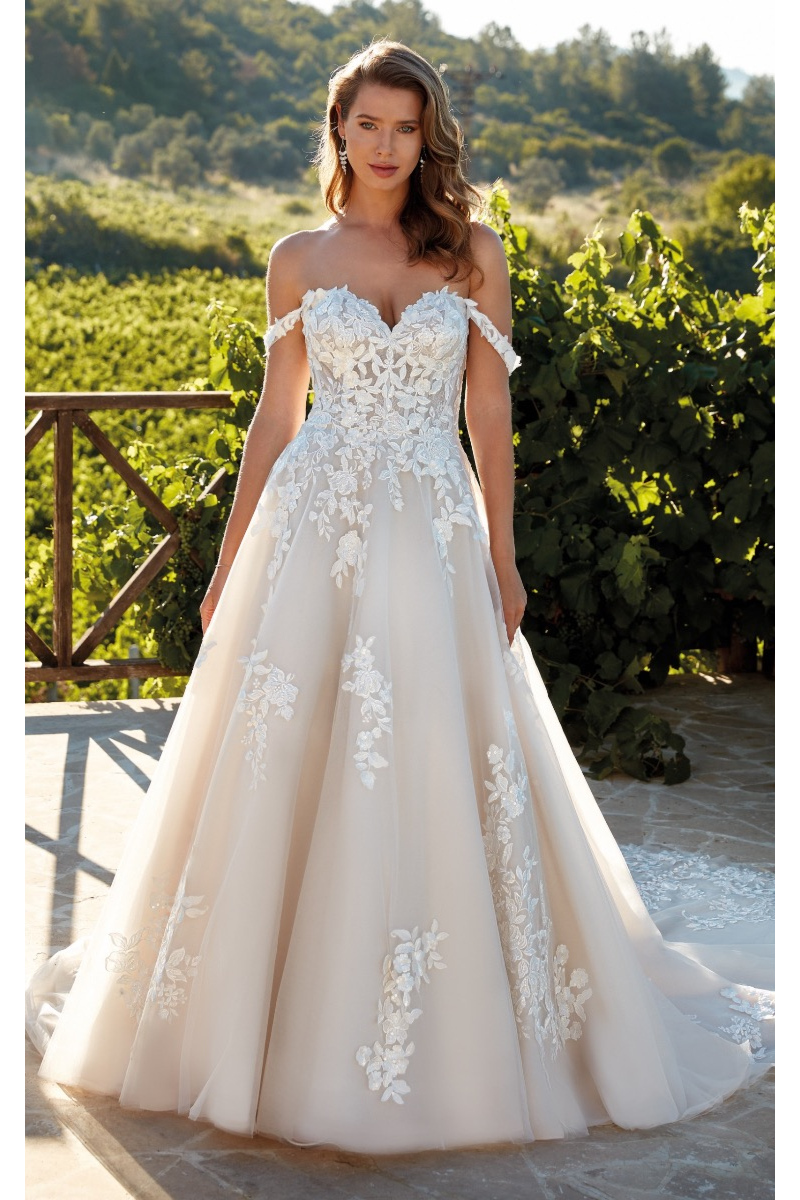 Abito da sposa WILLA di Eddy K con decorazioni floreali, sfondo naturale.