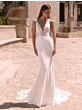 Abito da sposa NIREUS Bianco Evento, elegante e raffinato, con dettagli in pizzo, sfondo esterno.