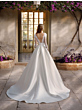 Abito da sposa Nicole Colet KEZIA con schiena scoperta e maniche lunghe in pizzo, ambientato in giardino fiorito.