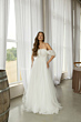 Abito da sposa LOVIA DIANA in tulle bianco con spalle scoperte, indossato in ambiente elegante.
