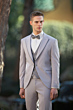 Abito da uomo elegante grigio chiaro con papillon, modello 22U152436C, sfondo naturale.