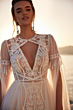 Abito da sposa ANWAR - DAMA, dettagli in pizzo, scollo a V, maniche trasparenti, sfondo tramonto.