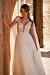 Abito da sposa AVA - DAMA con corpetto in pizzo e gonna in tulle, sfondo architettonico elegante.