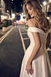 Abito da sposa DARIUS di Maggie Sottero, scollo a barca, città di notte sullo sfondo.