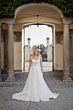 Abito da sposa Carena Linea Atelier Sposae in ambientazione elegante con colonne e cancello.