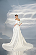 Abito da sposa L306 ARIAMO LIGHT, elegante e moderno con scollo a barca e gonna lunga, sfondo etereo.