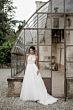 Abito da sposa elegante con top ricamato, ambientato in uno scenario rustico con serra in vetro.