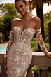 Abito da sposa PROCELLA DAMA con pizzo floreale su sfondo estivo.