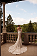 Abito da sposa PROCELLA - DAMA su terrazza con vista su giardino verde, design elegante e dettagli floreali.