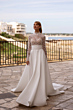 Abito da sposa Silene di Madioni, design elegante con corpetto in pizzo e gonna ampia, sfondo panoramico.