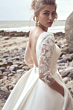Abito da sposa Magdalena di Maggie Sottero con maniche in pizzo, sfondo spiaggia.
