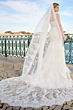 Abito da sposa NAOMI di Maggie Sottero, elegante con lungo strascico in pizzo, sfondo esterno.