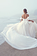 Abito da sposa Shasta Maggie Sottero sulla spiaggia, con strascico vaporoso e dettagli scintillanti.