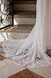 Abito da sposa ANITA - ROMANTICA BY SPOSAE, dettaglio strascico in pizzo su scala di marmo.