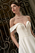 Abito da sposa elegante bianco, spalle scoperte, collezione Flavia Romantica. Sfondo con dettagli in ferro battuto.