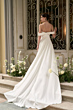 Abito da sposa elegante con spalle scoperte, coda lunga e dettagli floreali, collezione Flavia Romantica.