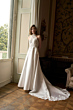 Abito da sposa Orietta, collezione Romantica, con pizzo e strascico, in elegante salone con finestra.