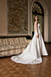 Abito da sposa Orietta, collezione Romantica, in salone elegante con divano classico e arazzo floreale.