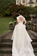 Abito da sposa Beatrice con schiena a cuore, collezione Romantica, ambientato in giardino elegante.