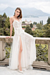 Abito da sposa Selene, The Romantica Collection, in pizzo bianco con spacco, ambientazione esterna elegante.