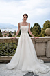 Abito da sposa Maria, collezione Romantica, con dettagli floreali, sfondo paesaggio naturale.