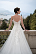 Abito da sposa Maria, collezione Romantica, con dettagli floreali, vista posteriore, sfondo paesaggio naturale.