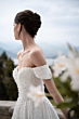 Abito da sposa elegante con perle, collezione Romantica, sfondo naturale.