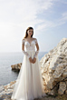 Abito da sposa Oreasposa L1071, scollo a cuore e pizzo, sfondo mare e rocce.